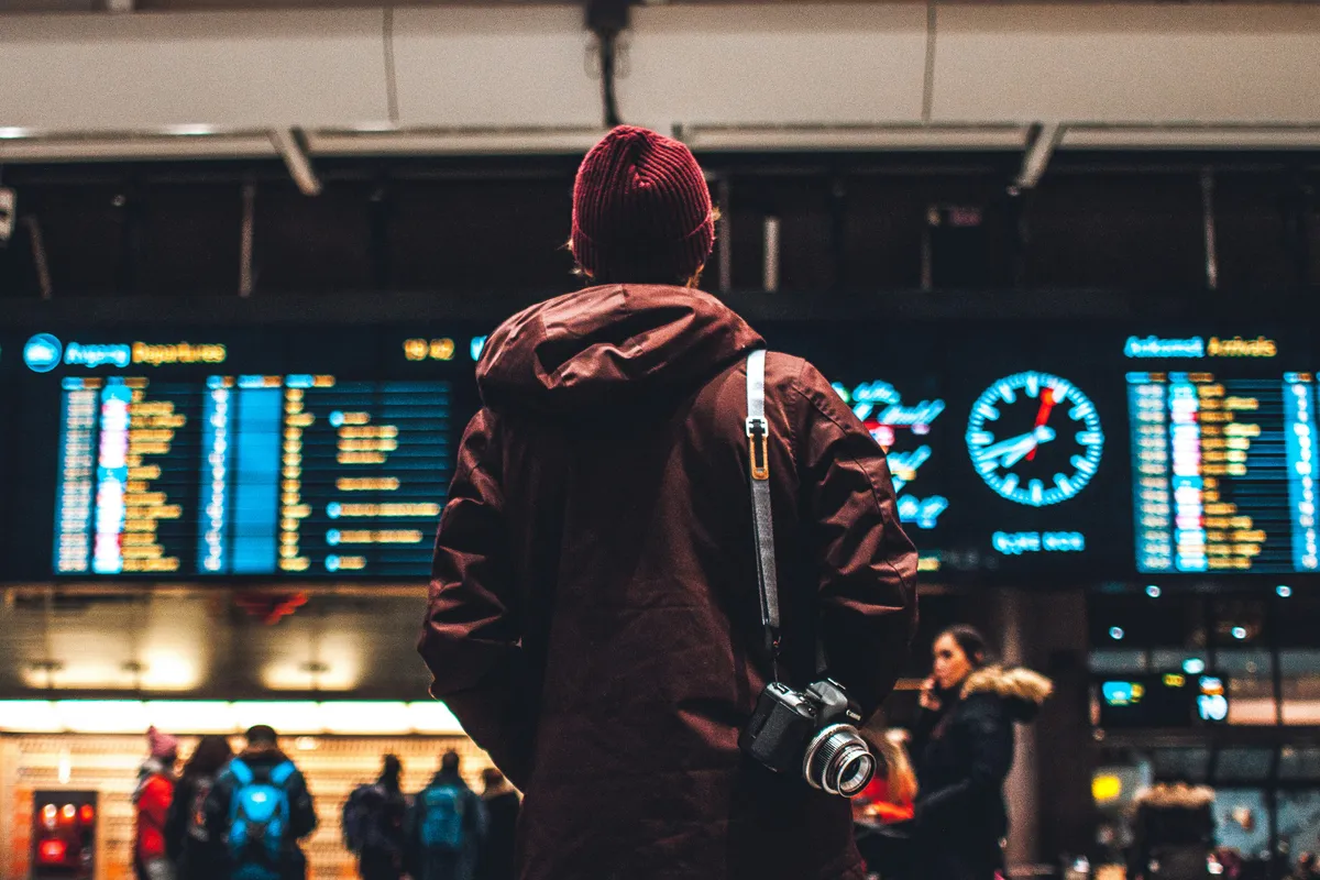 Traveler looking at a departure board at an airport, Japan